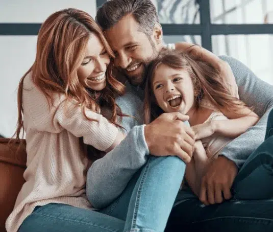 Happy family of three, having a playful cuddle together.