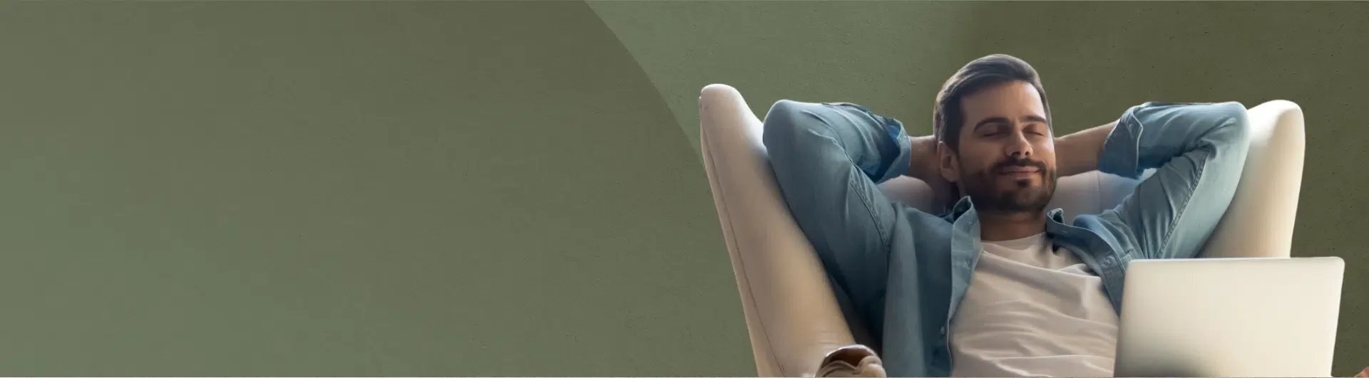 A happy man, sitting back in a chair relaxed, looking content.